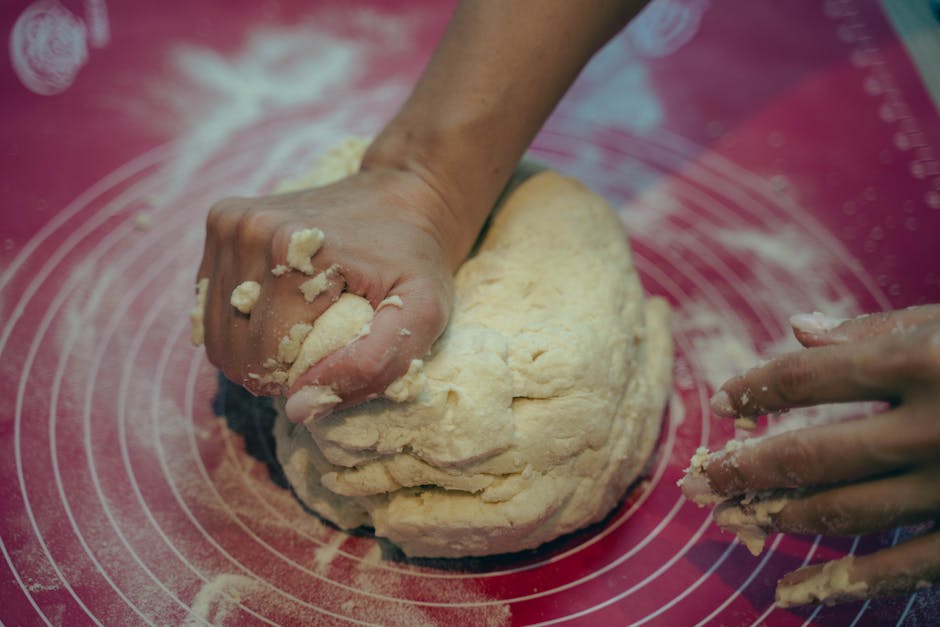 Pâte à biscuits en train d'être pétrie à la main